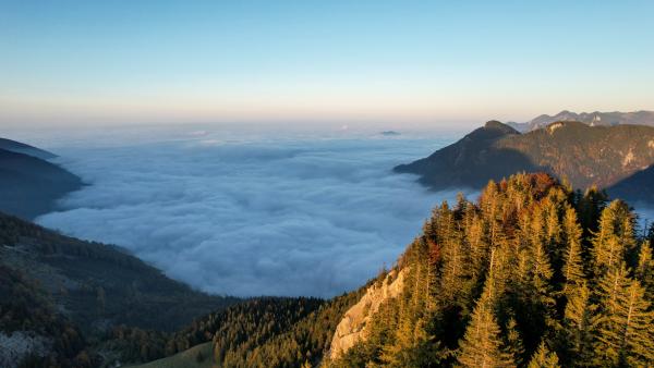 This image was taken over the clouds. You see them till the horizon. Mountain tops look like islands. A peek is in the foreground.