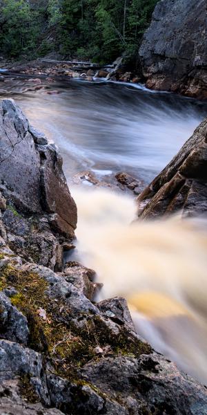 A selfportrait of me sitting on a rock next to a waterfall. The waterfall is washed out because of long exposure.