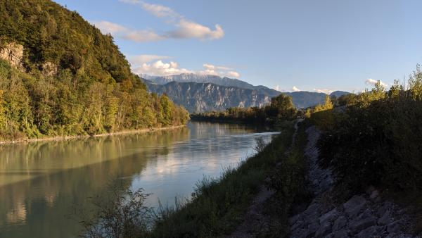 A flowing river in a mountainous landscape, with clear waters and surrounding natural scenery.