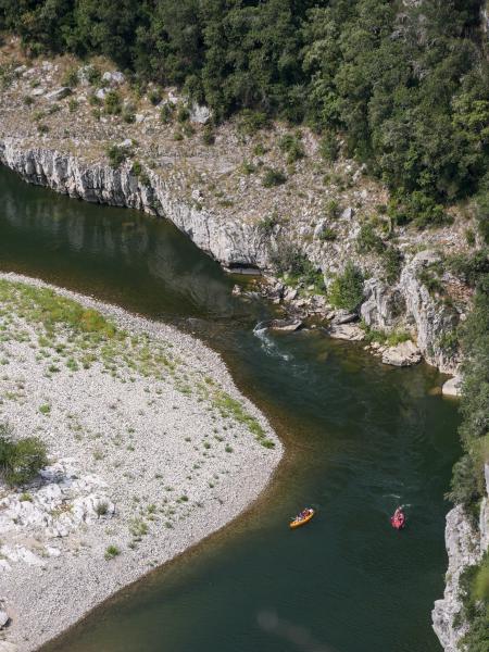 Image of a river in france in a rocky terrain. In this image there are two canoes.