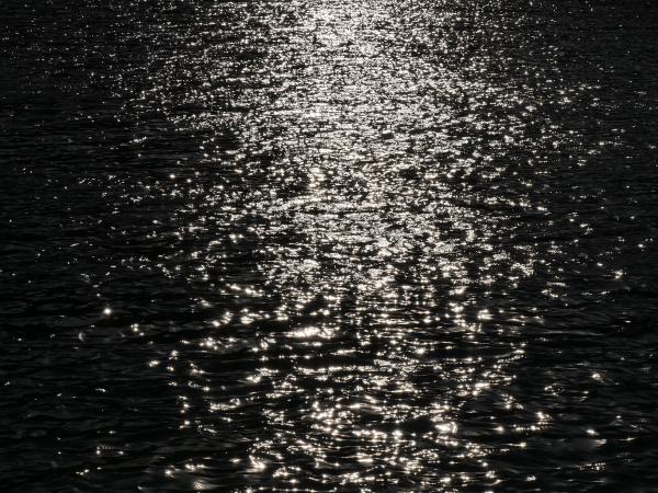 The shining reflection of the sun in the water of a lake.