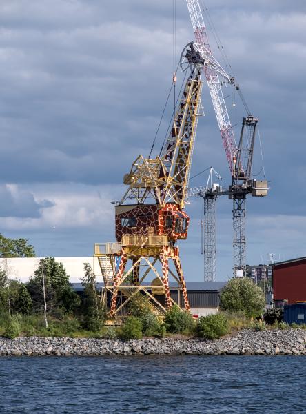 A girafe shaped crane at the coast.