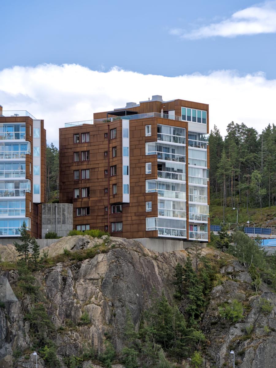 Ein Wohnblock in Stockholm. Der Block ist außen braun und hat viele Balkone.