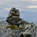 Gipfelkönig - Wanderer steht neben einem Steinmann im schwedischen Fjäll