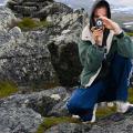 Foto vom Gipfel - Wanderer mit Kamera neben einem Steinmann im schwedischen Fjäll