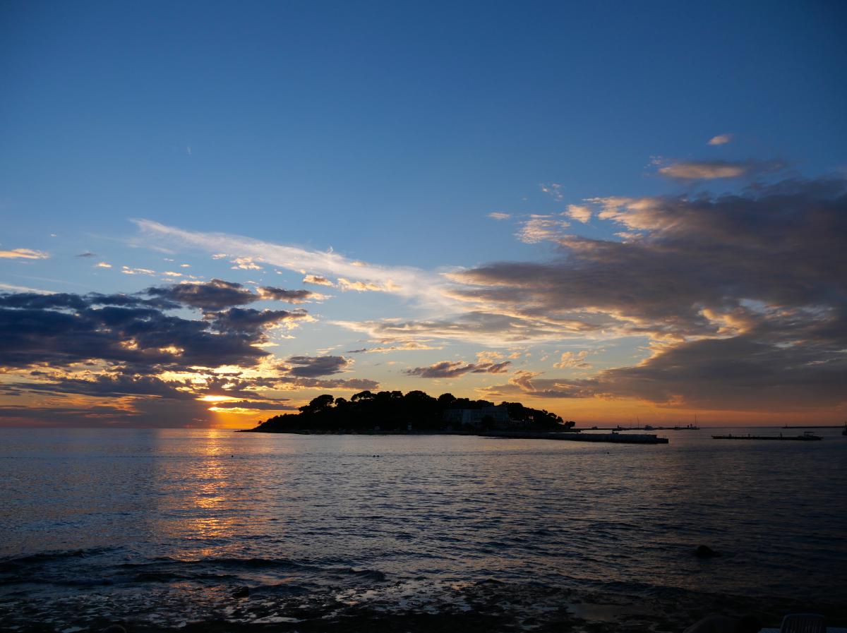 Photo of the sunset in Croatia. The sun is setting near an island.