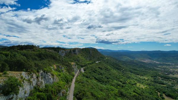 Image of little mountains / hills and a railroad track snaking along them. On this image the focus lies more on the track.