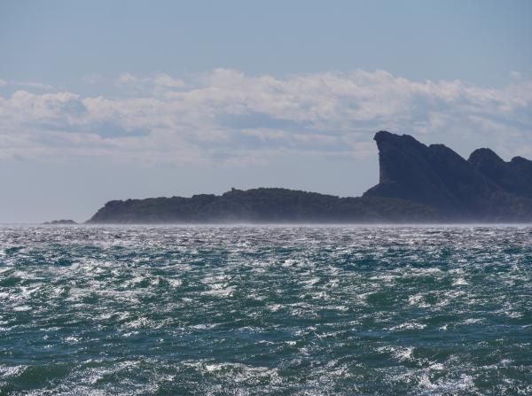 Photo of an island taken in France. The sea is rough but the weather is good.