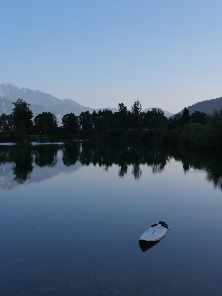 Ein kleiner See mit Bergen im Hintergrund.