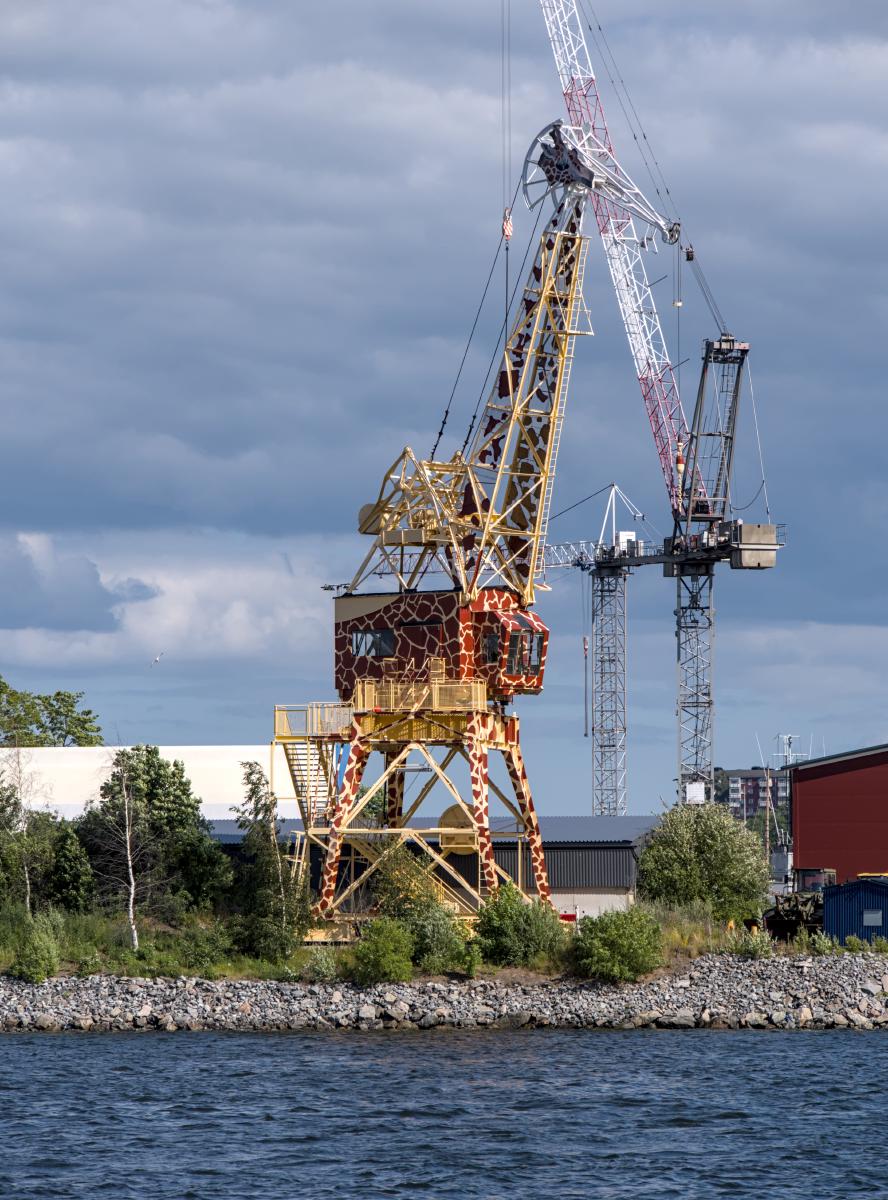 En giraffformad lyftkran vid kusten.