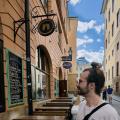 Time for a Beer - German Man Standing Before a Beer Sign in Gamla Stan