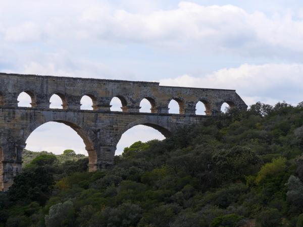 Ein Foto eines Aquädukts in Frankreich mit grünen Bäumen im Hintergrund.