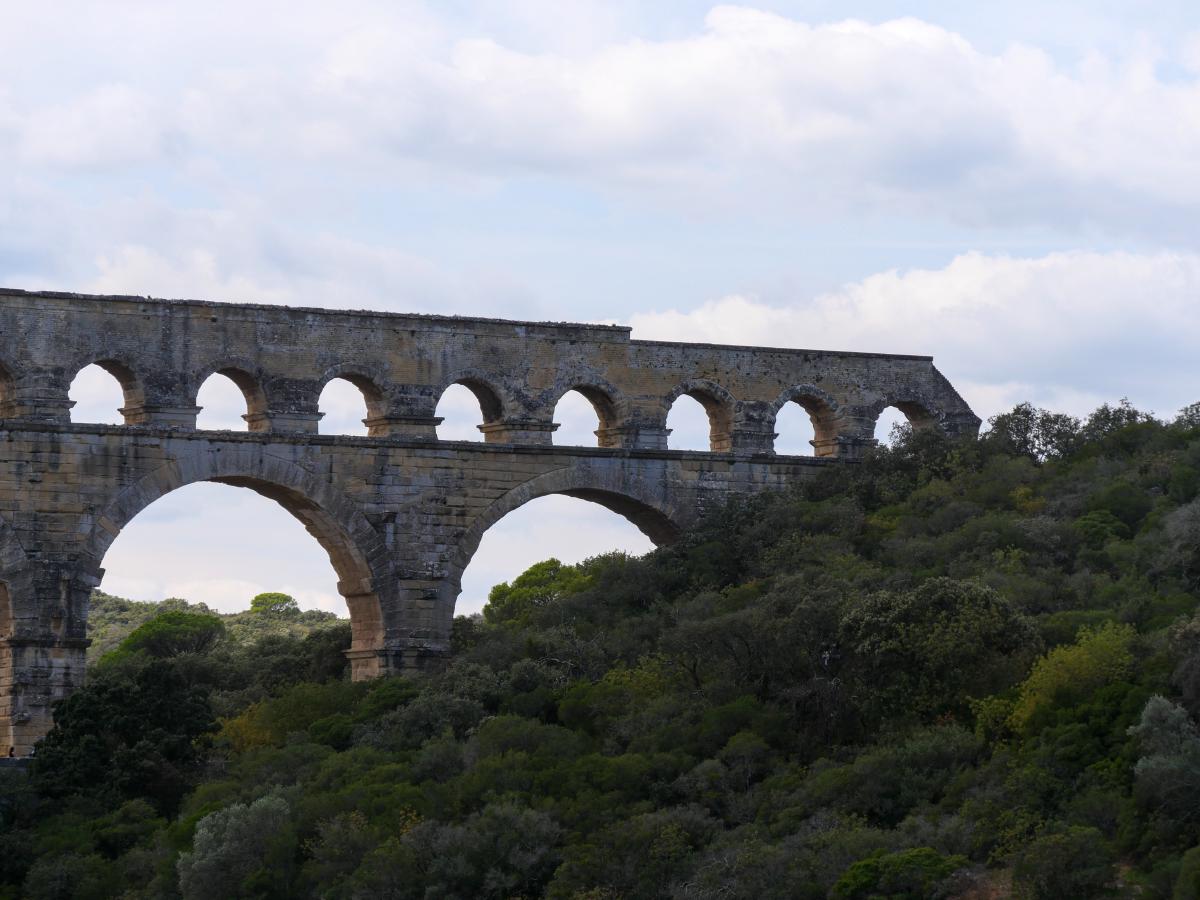 Ein Foto eines Aquädukts in Frankreich mit grünen Bäumen im Hintergrund.