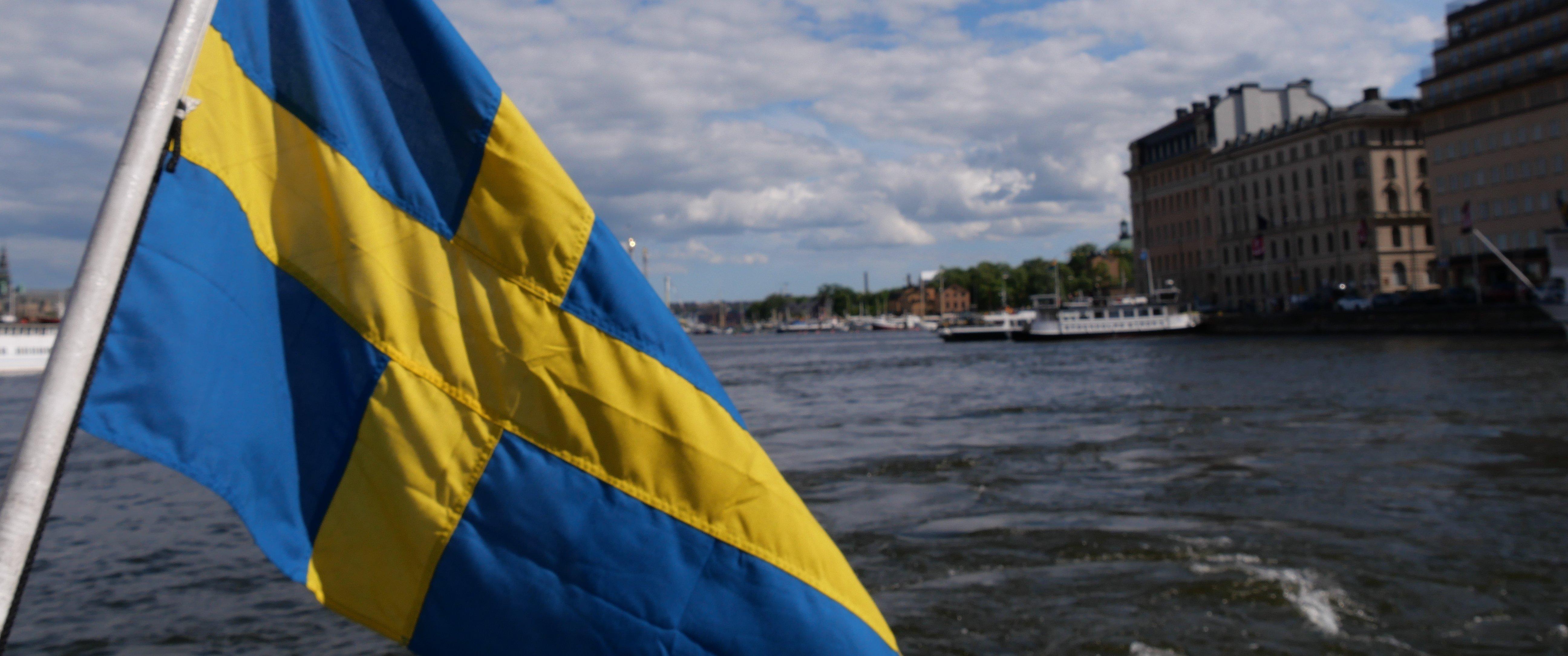 Flagga på en båt med Stockholm i bakgrunden